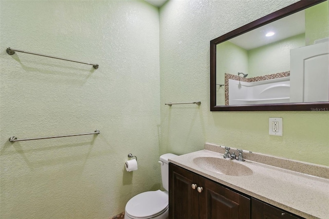 7507 Beasley Rd, Tampa, FL 33615 - bathroom featuring vanity, toilet, and a textured wall