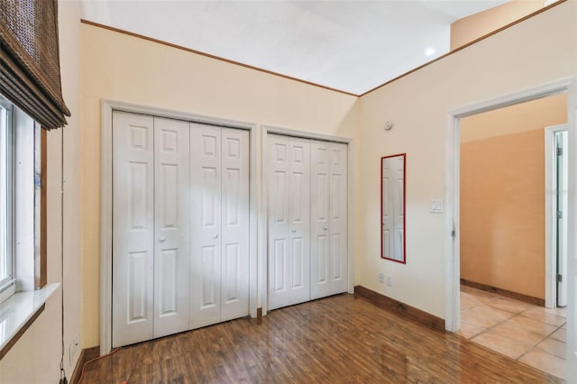 7507 Beasley Rd, Tampa, FL 33615 - unfurnished bedroom featuring two closets, wood finished floors, and baseboards