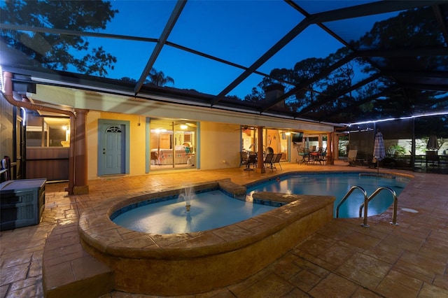 7507 Beasley Rd, Tampa, FL 33615 - pool at night with a patio, ceiling fan, glass enclosure, a pool with connected hot tub, and outdoor dining area