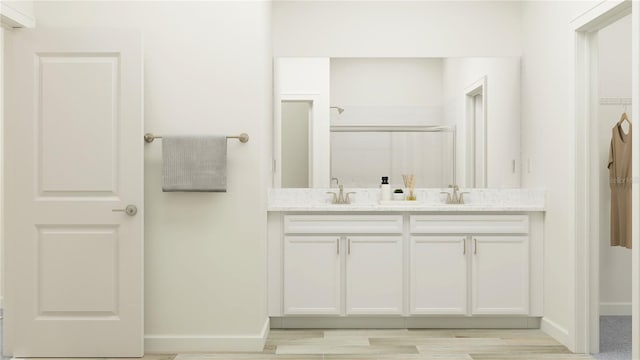 12597 Lily Quartz Loop, Parrish, FL 34219 - full bath featuring a stall shower, baseboards, double vanity, and wood finished floors