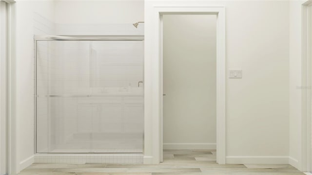 12597 Lily Quartz Loop, Parrish, FL 34219 - bathroom with a stall shower, baseboards, and wood finished floors