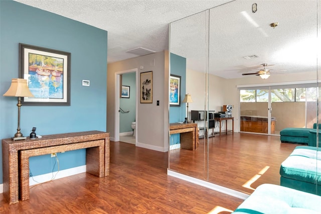 2444 Laurelwood Dr Unit A, Clearwater, FL 33763 - living room featuring wood finished floors, a textured ceiling, baseboards, ceiling fan, and a desk