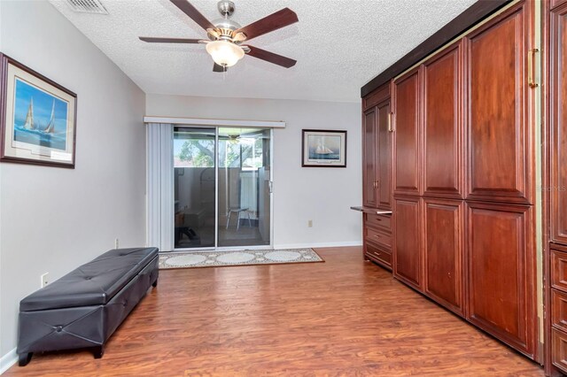 2444 Laurelwood Dr Unit A, Clearwater, FL 33763 - unfurnished room featuring ceiling fan, wood finished floors, a textured ceiling, and baseboards