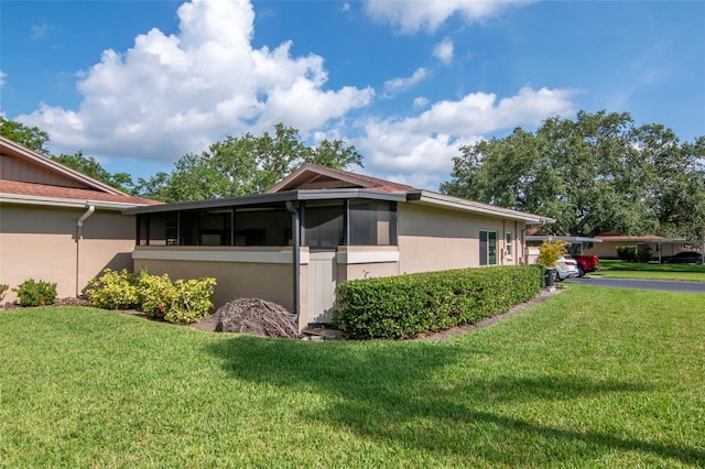 2444 Laurelwood Dr Unit A, Clearwater, FL 33763 - view of property exterior featuring a yard, a sunroom, and stucco siding