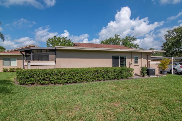 2444 Laurelwood Dr Unit A, Clearwater, FL 33763 - rear view of house with stucco siding, central AC unit, and a yard