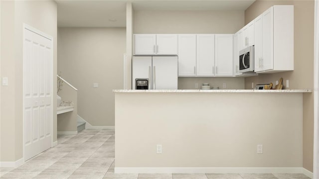 11083 E 65th Ter, Palmetto, FL 34221 - kitchen with white refrigerator with ice dispenser, white cabinetry, a peninsula, baseboards, and light countertops