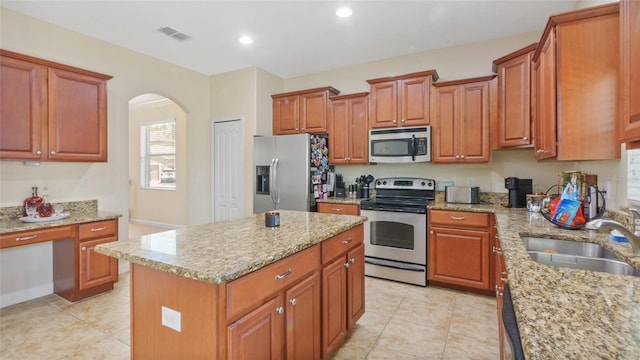 3862 Tristram Loop, Land O Lakes, FL 34638 - kitchen featuring stainless steel appliances, a sink, arched walkways, light stone counters, and recessed lighting