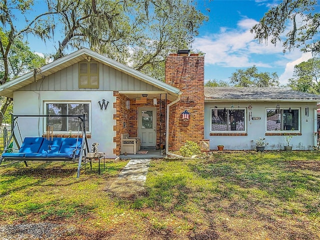 11912 Mcmullen Loop, Riverview, FL 33569 - view of front of home with a chimney, a front lawn, and stucco siding