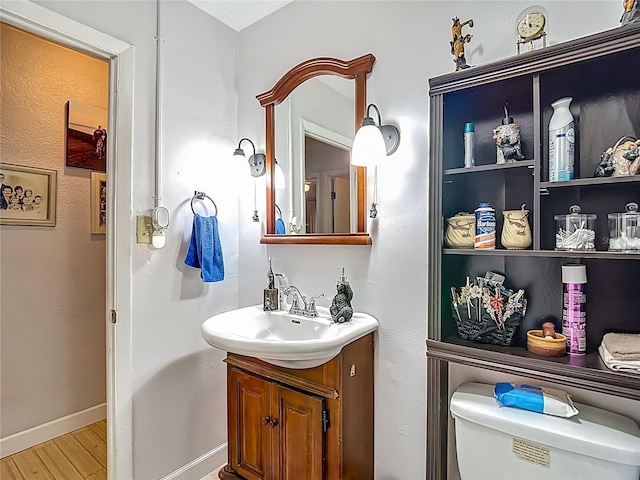 11912 Mcmullen Loop, Riverview, FL 33569 - bathroom featuring vanity, wood finished floors, toilet, and baseboards