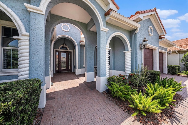 10645 Ruffino Ct, Trinity, FL 34655 - property entrance featuring an attached garage, stucco siding, and driveway