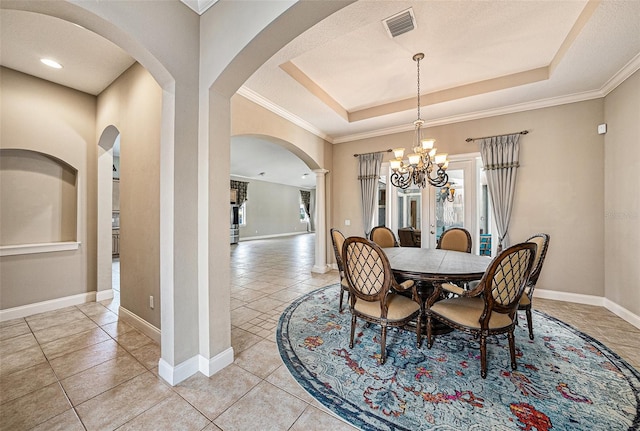 10645 Ruffino Ct, Trinity, FL 34655 - dining space featuring a tray ceiling, a chandelier, arched walkways, baseboards, and light tile patterned floors