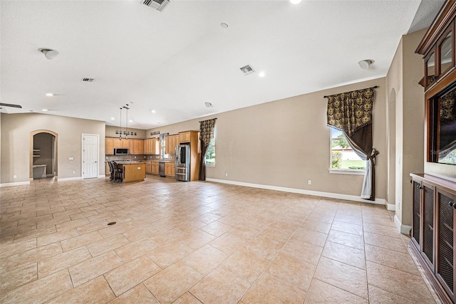 10645 Ruffino Ct, Trinity, FL 34655 - unfurnished living room with arched walkways, baseboards, and recessed lighting