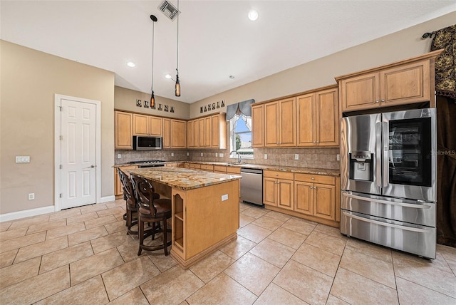 10645 Ruffino Ct, Trinity, FL 34655 - kitchen featuring appliances with stainless steel finishes, a sink, decorative backsplash, a kitchen island, and light stone countertops