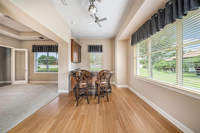 10645 Ruffino Ct, Trinity, FL 34655 - dining space featuring baseboards, light wood finished floors, a ceiling fan, and a dry bar