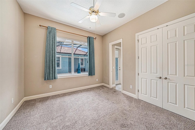 10645 Ruffino Ct, Trinity, FL 34655 - unfurnished bedroom featuring carpet flooring, a closet, baseboards, ceiling fan, and a textured ceiling