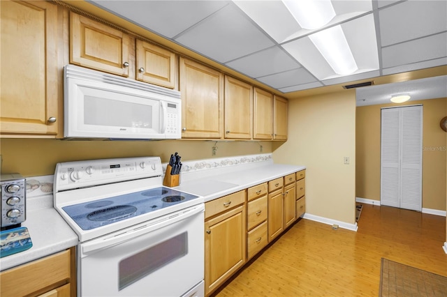 6265 Sun Blvd Unit 605, Saint Petersburg, FL 33715 - kitchen featuring white appliances, light countertops, light wood-type flooring, and baseboards