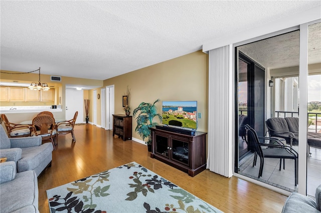 6265 Sun Blvd Unit 605, Saint Petersburg, FL 33715 - living room with light wood finished floors, a textured ceiling, and a chandelier