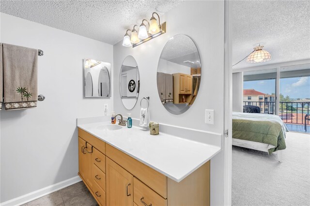 6265 Sun Blvd Unit 605, Saint Petersburg, FL 33715 - ensuite bathroom featuring a textured ceiling, vanity, and baseboards