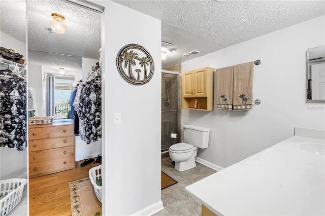 6265 Sun Blvd Unit 605, Saint Petersburg, FL 33715 - bathroom with a textured ceiling, a shower stall, vanity, and toilet