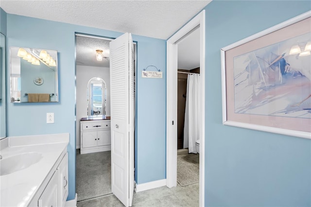 6265 Sun Blvd Unit 605, Saint Petersburg, FL 33715 - bathroom with a textured ceiling, vanity, toilet, and curtained shower