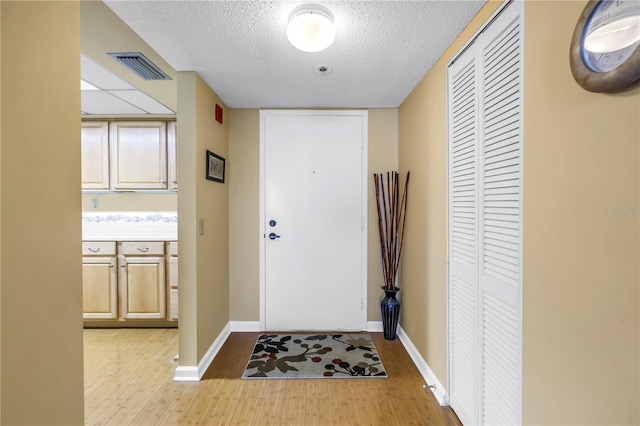 6265 Sun Blvd Unit 605, Saint Petersburg, FL 33715 - entrance foyer with light wood-style flooring, a textured ceiling, and baseboards