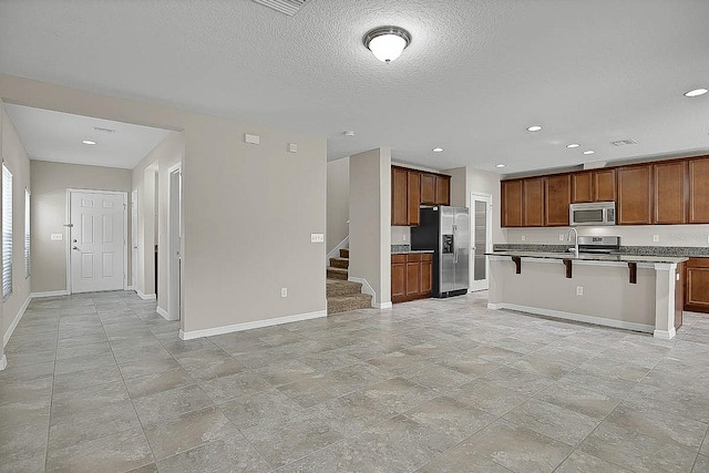 16016 Persimmon Grove Dr, Lithia, FL 33547 - kitchen with appliances with stainless steel finishes, baseboards, a kitchen breakfast bar, open floor plan, and recessed lighting