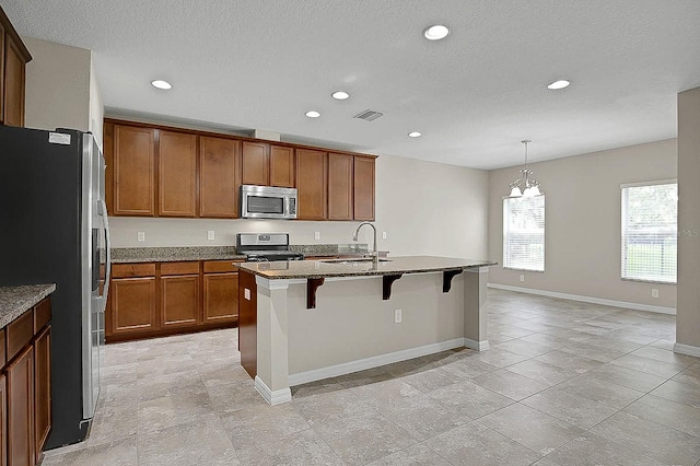 16016 Persimmon Grove Dr, Lithia, FL 33547 - kitchen with appliances with stainless steel finishes, a sink, recessed lighting, a kitchen bar, and brown cabinets