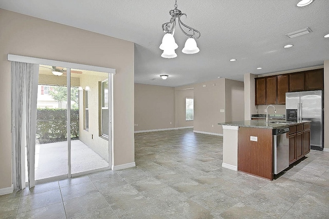 16016 Persimmon Grove Dr, Lithia, FL 33547 - kitchen with appliances with stainless steel finishes, baseboards, a sink, dark stone countertops, and hanging light fixtures