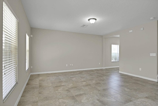 16016 Persimmon Grove Dr, Lithia, FL 33547 - spare room with baseboards, stone finish floors, a textured ceiling, and a smoke detector