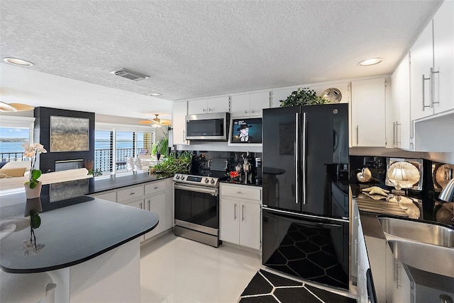 7520 Sunshine Skyway Ln S Unit 109, Saint Petersburg, FL 33711 - kitchen with appliances with stainless steel finishes, dark countertops, healthy amount of natural light, recessed lighting, and white cabinetry