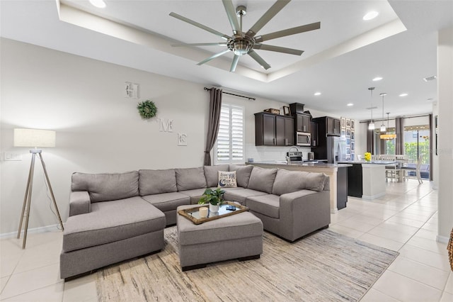 1321 Custer Bayou St, Ruskin, FL 33570 - living room featuring a raised ceiling, ceiling fan, light tile patterned flooring, recessed lighting, and baseboards
