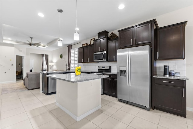 1321 Custer Bayou St, Ruskin, FL 33570 - kitchen with stainless steel appliances, backsplash, a kitchen island, open floor plan, and recessed lighting