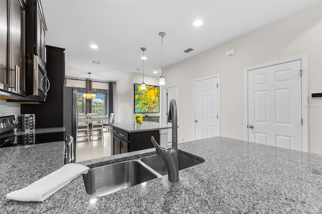 1321 Custer Bayou St, Ruskin, FL 33570 - kitchen featuring recessed lighting, stainless steel appliances, dark stone countertops, pendant lighting, and a center island