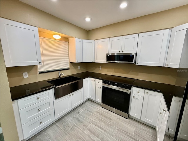440 89th Ave, St Pete Beach, FL 33706 - kitchen with wall oven, stainless steel microwave, a sink, white cabinetry, and recessed lighting