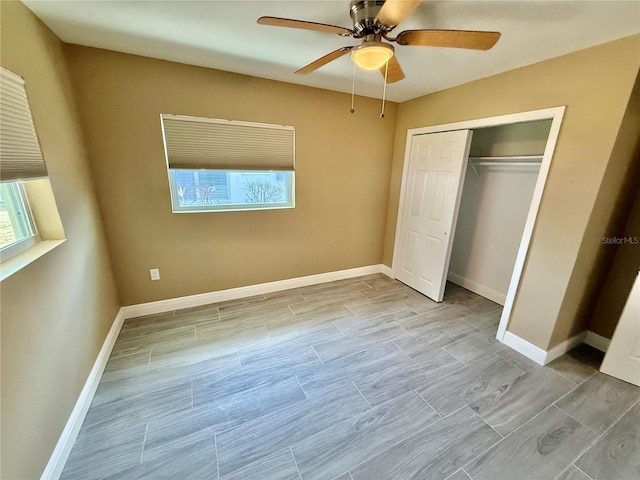 440 89th Ave, St Pete Beach, FL 33706 - unfurnished bedroom with a closet, baseboards, a ceiling fan, and wood tiled floors