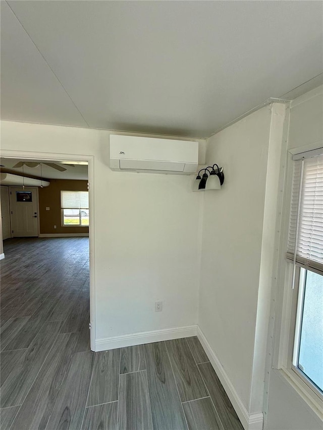 440 89th Ave, St Pete Beach, FL 33706 - spare room featuring an AC wall unit, baseboards, and dark wood-style flooring