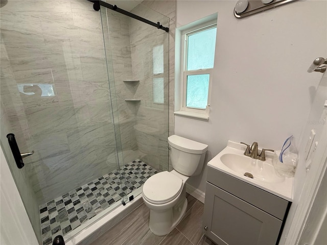 440 89th Ave, St Pete Beach, FL 33706 - bathroom with toilet, a shower stall, vanity, baseboards, and wood finished floors