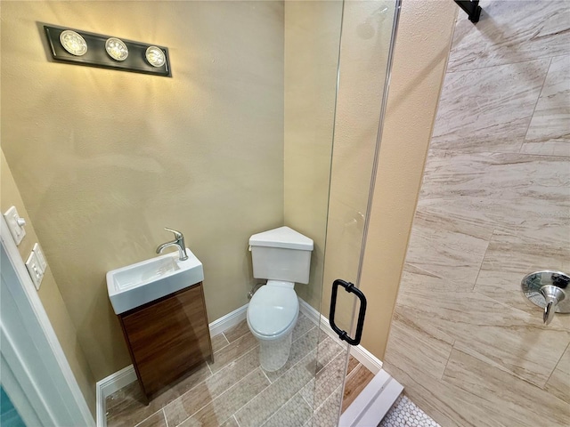 440 89th Ave, St Pete Beach, FL 33706 - full bath featuring toilet, vanity, tile patterned floors, baseboards, and a shower with shower door