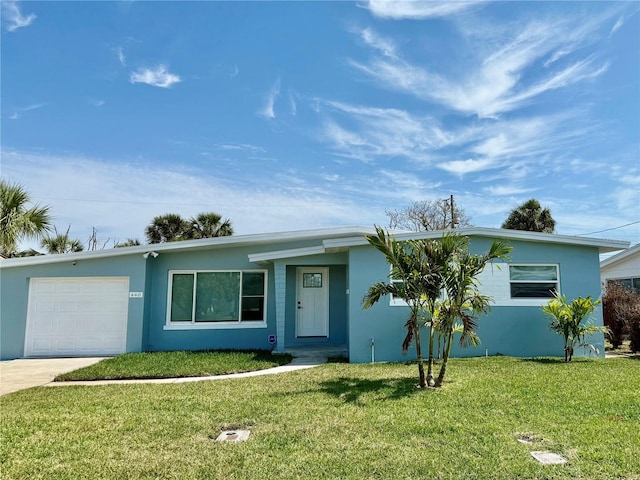 440 89th Ave, St Pete Beach, FL 33706 - view of front of home featuring an attached garage, a front lawn, stucco siding, and concrete driveway
