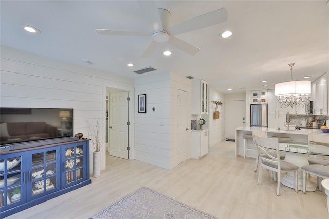 230 Medallion Blvd Unit F, Madeira Beach, FL 33708 - living area with a chandelier, recessed lighting, light wood-style floors, a ceiling fan, and wood walls