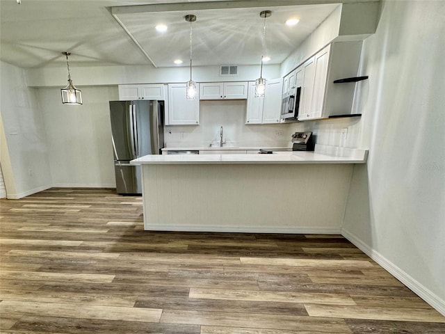 2690 Coral Landings Blvd Unit 217, Palm Harbor, FL 34684 - kitchen featuring stainless steel appliances, baseboards, a peninsula, light countertops, and dark wood-type flooring