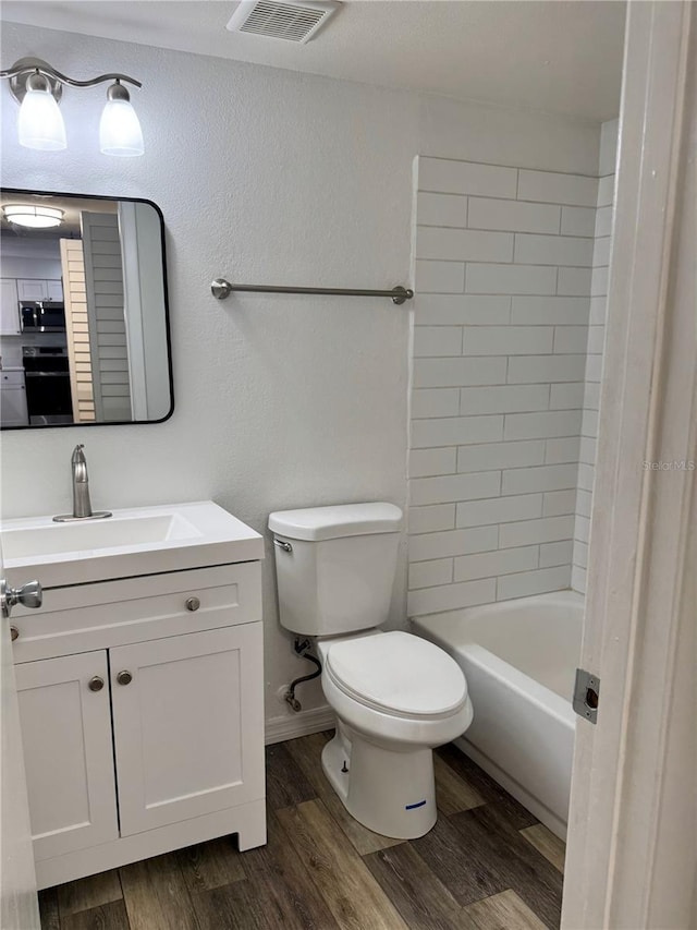 2690 Coral Landings Blvd Unit 217, Palm Harbor, FL 34684 - full bathroom featuring toilet, vanity, wood finished floors, and  shower combination
