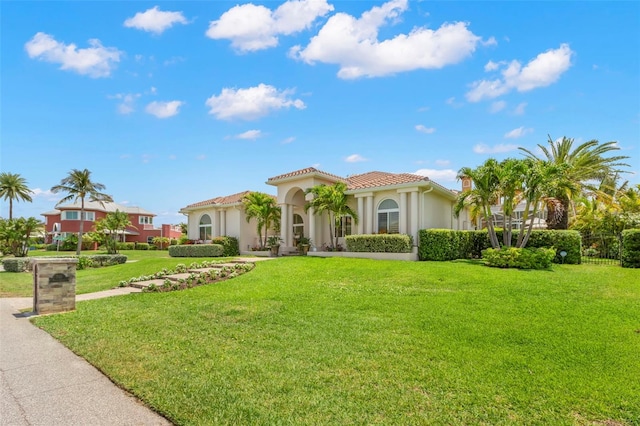703 Monte Cristo Blvd, Tierra Verde, FL 33715 - mediterranean / spanish home featuring stucco siding, a front lawn, and a tiled roof
