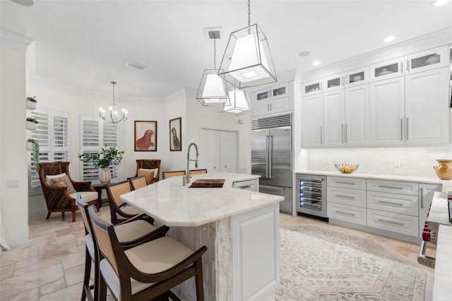 703 Monte Cristo Blvd, Tierra Verde, FL 33715 - kitchen featuring built in fridge, beverage cooler, a sink, a chandelier, and light countertops