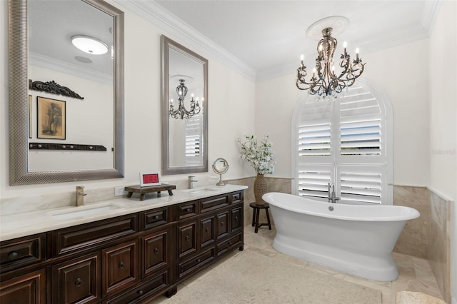 703 Monte Cristo Blvd, Tierra Verde, FL 33715 - bathroom with a chandelier, ornamental molding, double vanity, a wainscoted wall, and a freestanding tub