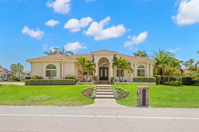 703 Monte Cristo Blvd, Tierra Verde, FL 33715 - mediterranean / spanish house featuring french doors, stucco siding, a front yard, and a tile roof