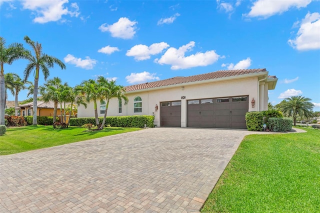 703 Monte Cristo Blvd, Tierra Verde, FL 33715 - mediterranean / spanish house with a garage, decorative driveway, stucco siding, a front yard, and a tile roof