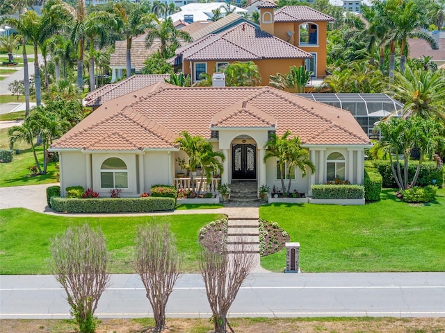 703 Monte Cristo Blvd, Tierra Verde, FL 33715 - mediterranean / spanish-style house with french doors, a front lawn, stucco siding, and a tiled roof