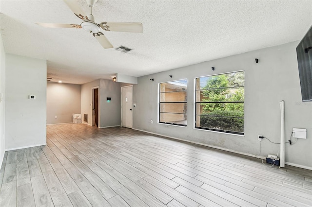 2410 Covington Ave, Spring Hill, FL 34608 - unfurnished living room featuring wood finished floors, a textured ceiling, ceiling fan, and baseboards