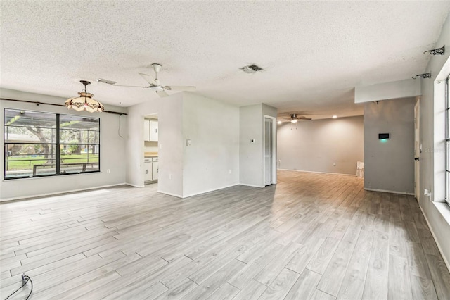 2410 Covington Ave, Spring Hill, FL 34608 - unfurnished living room featuring a ceiling fan, a textured ceiling, wood finished floors, and baseboards